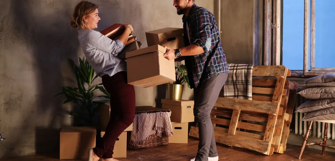 A couple carrying boxes during a full house clearance